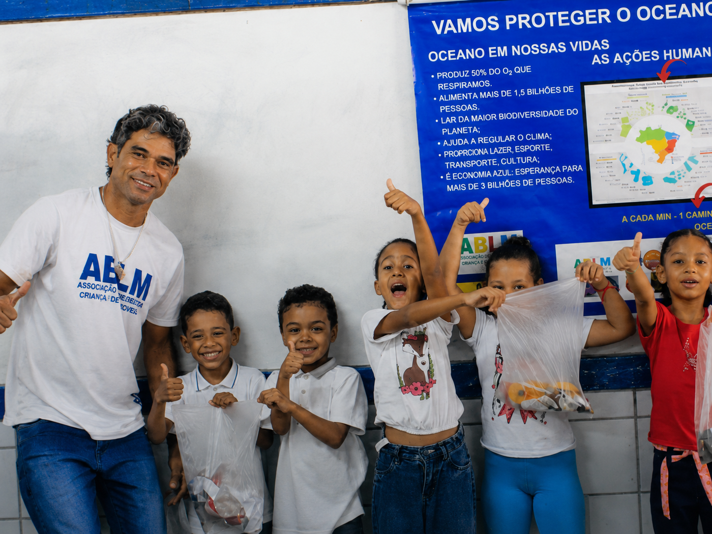 A local community leader and children celebrating an environmental education project in Brazil